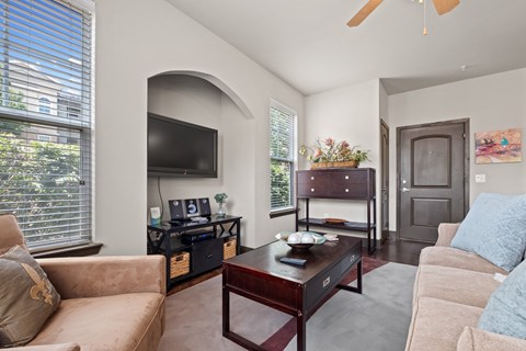 a living room with a couch and a coffee table and a television a living room with a couch and a coffee table and a television at The Millennium Towne Center Apartments, Baton Rouge